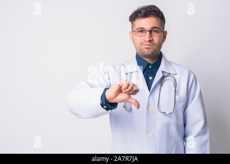 Portrait of stressed young Persian man doctor giving thumbs down Stock Photo