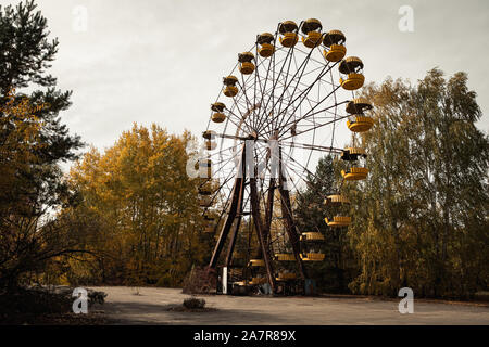 Famous ferris wheel in abandoned amusement park in the empty city of Pripyat near the Chernobyl nuclear reactor during autumn (Kiew, Ukraine, Europe) Stock Photo