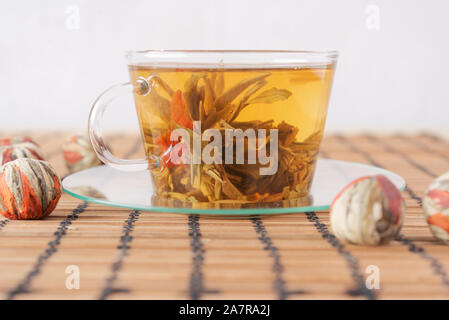 Cup of green tea with red lily flower Stock Photo