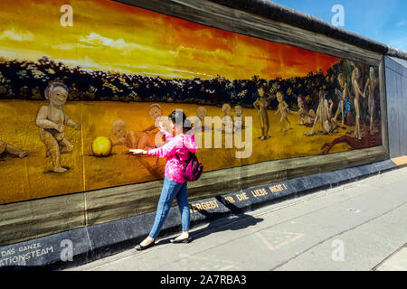 Berlin wall graffiti tourist street art Asian woman at East Side Gallery Germany Friedrichshain city street Don´t Forget The Love by Henry Schmidt Stock Photo