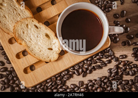 bread for breakfast, with cup of coffee over rustic wooden background with copy space. Morning breakfast with coffee and toasts. Stock Photo