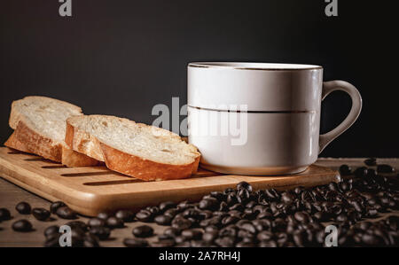 bread for breakfast, with cup of coffee over rustic wooden background with copy space. Morning breakfast with coffee and toasts. Stock Photo