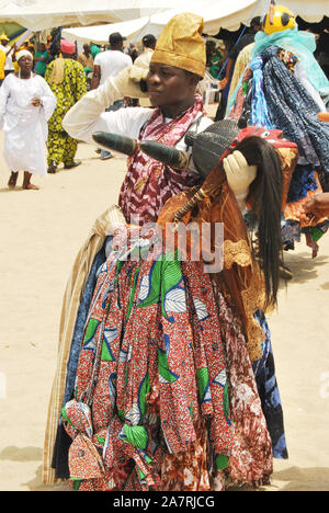 A Gelede Masker receiving a call during the Annual Black Heritage Festival, Badagry, Lagos Nigeria. Stock Photo