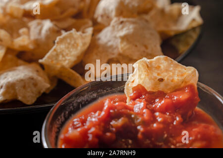 plate with taco, nachos chips and tomato dip. Spicy Nachos (close-up shot) on rustic wooden background Stock Photo