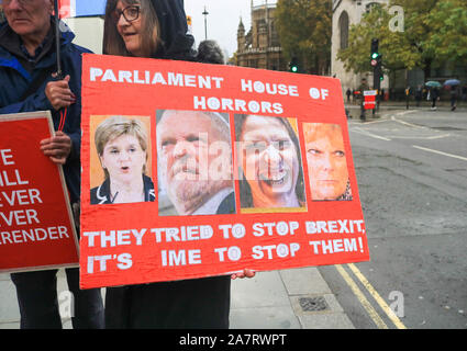 London, UK. 4 November 2019 A Pro Brexit protester outside Parliament holds a placard with pictures of remain politicians  Scotland First Minister Nicola Sturgeon, Labour leader Jeremy Corbyn, Liberal Democrat leader Jo Swinson and Change UK MP Anna Soubry. Political parties have  started  campaigning ahead of the general election on 12 December. amer ghazzal /Alamy live News Stock Photo