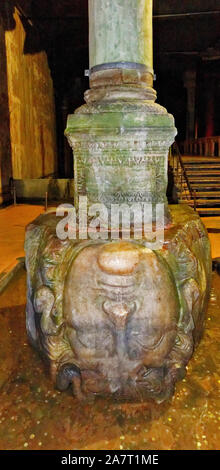 ISTANBUL TURKEY THE BASILICA CISTERN COLUMNS AND A MARBLE MEDUSA HEAD SCULPTURE USED AS A COLUMN BASE LYING IN A POOL OF WATER WITH COINS Stock Photo