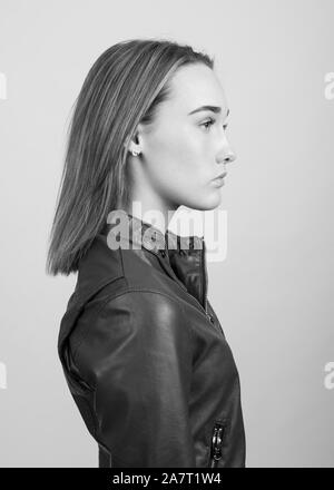 Profile portrait of a young woman wearing a leather jacket in black and white Stock Photo