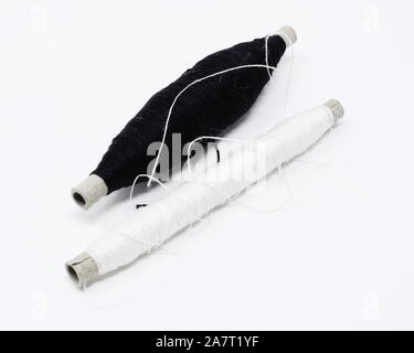 two weaving quills/perns partly filled with black and white mercerized cotton yarn Stock Photo