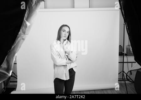 Grayscale portrait of a young woman wearing a leather jacket in studio Stock Photo