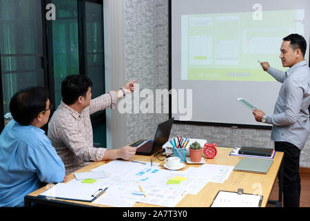 Graphic designers presenting UX UI designer planning application template layout framework for mobile phone computer mobile to developer team Stock Photo
