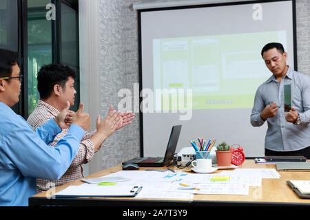 Graphic designers presenting UX UI designer planning application template layout framework for mobile phone computer mobile to developer team Stock Photo