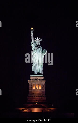 Statue of Liberty at night photographed from the Staten Island Ferry, New York City, United States of America. Stock Photo