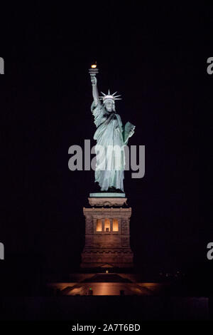 Statue of Liberty at night photographed from the Staten Island Ferry, New York City, United States of America. Stock Photo