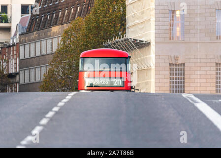 Red London bus driving over Lambeth Bridge, London, UK. Route 211 to Waterloo. Rising up behind crest of bridge over River Thames. Hidden from view Stock Photo