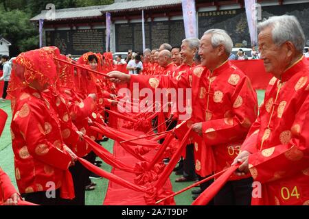 Chinese elderly couples take part in a group wedding ceremony to celebrate traditional Chinese festival Qixi Festival, also known as the Chinese Valen Stock Photo