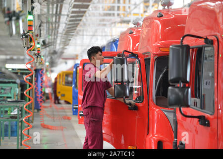 --FILE--A Chinese worker assembles vehicles on the assembly line at an ...