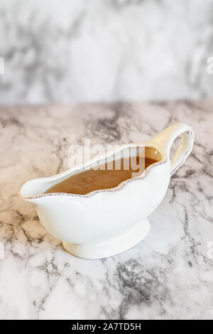 Homemade turkey gravy in a gravy boat or sauceboat ready for Thanksgiving Day. Stock Photo
