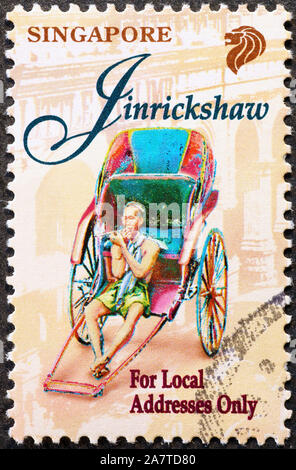 Rickshaw and man on postage stamp of Singapore Stock Photo