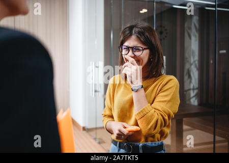Group of happy business woman have meeting at modern office. Two positive female employees standing at open space and discuss working moment Stock Photo