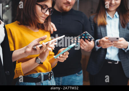 Close-up of  business people working together and using modern smartphone at office. Digital gadgets using concept Stock Photo