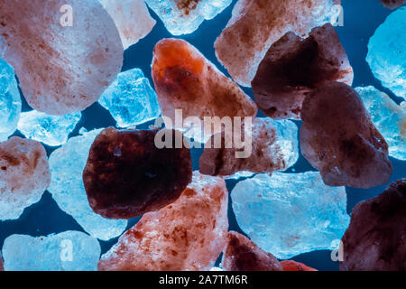 abstract background with pink salt stones, abstract floating salt rocks on blue background Stock Photo