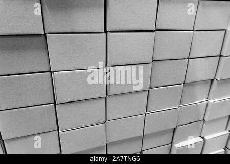Isolated close-up of stacked wall made of multiple blank white closed rectangular cardboard boxes, used for delivering consumer goods. Symbol of packa Stock Photo