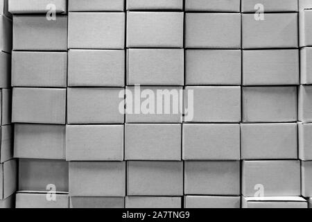 Isolated close-up of stacked wall made of multiple blank white closed rectangular cardboard boxes, used for delivering consumer goods. Symbol of packa Stock Photo