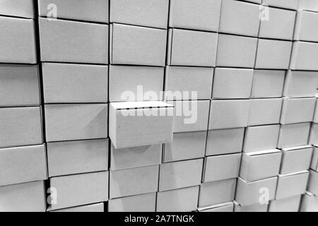Isolated close-up of stacked wall made of multiple blank white closed rectangular cardboard boxes, used for delivering consumer goods. Symbol of packa Stock Photo