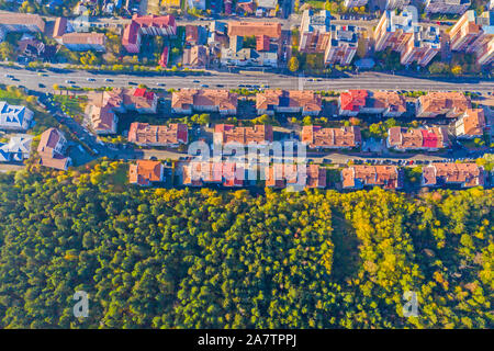 Residential buildings near green forest viewed from above Stock Photo