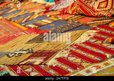 closeup of assortment of Moroccan carpets resting on the ground in a souk Stock Photo