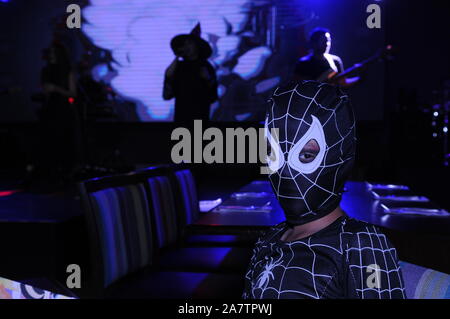 Mixed race boy (Cambodian - American) in a spider-man costume during a Halloween show. The Hard Rock Cafe, Phnom Penh, Cambodia. © Kraig Lieb Stock Photo