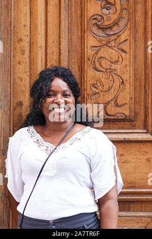 cuban woman in front of carved wooden door Stock Photo