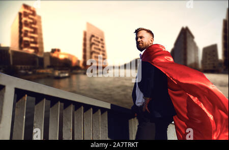 Successful superhero businessman on a business building background Stock Photo