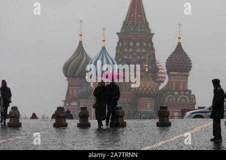 Rainy weather in Moscow. A couple with umbrella on Red square on the background of St. Basil's Cathedral in central Moscow, Russia Stock Photo