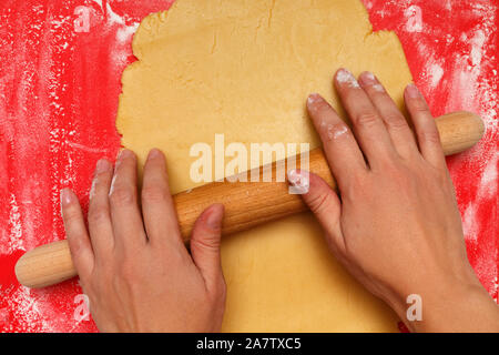 Female hands roll out the dough for Christmas cookies. Stock Photo