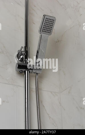 Wet shower head hanging on the wall Stock Photo