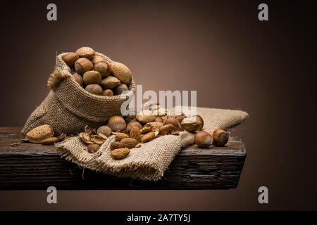 variety of nuts on wooden table with dark background Stock Photo