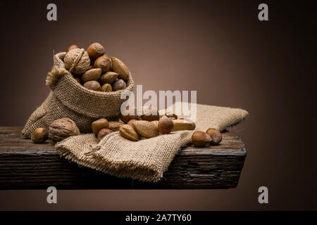variety of nuts on wooden table with dark background Stock Photo