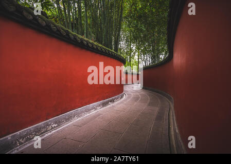 A passageway through Wuhou Shrine in Chengdu, China, is flanked on either side by bright red walls. Stock Photo