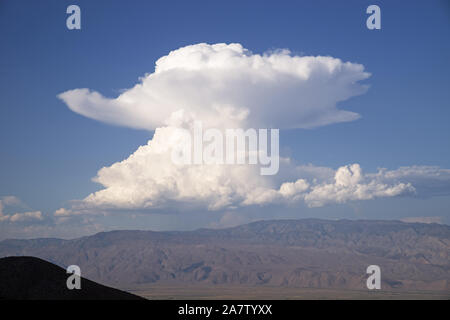 cumulonimbus cloud towers over the Inyo Mountains in a mushroom shape Stock Photo