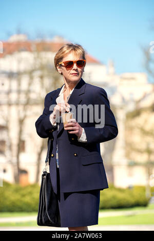 An elegant business woman on the street enjoy coffee from paper cup Stock Photo