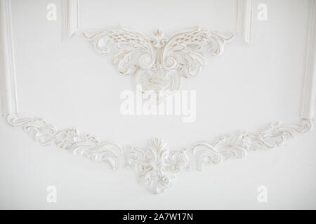 Expensive interior. Stucco elements on light luxury wall. White patterned. Mouldings element from gypsum. Stock Photo