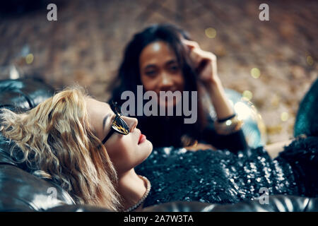 Pretty young woman relax and lying on sofa after crazy party. Holiday Event, rest concept Stock Photo