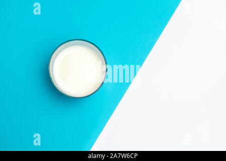 Cup of fermented drink ayran (kefir) on blue and white geometric background Stock Photo