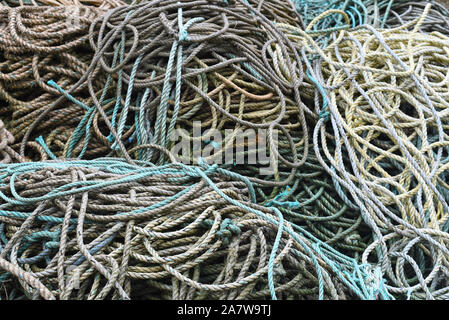 Close up of fisherman’s ropes piled on the harbour on a wet rainy day. Stock Photo