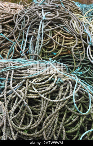 Close up of fisherman’s ropes piled on the harbour on a wet rainy day. Stock Photo