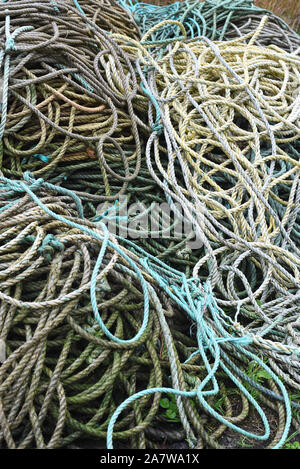 Close up of fisherman’s ropes piled on the harbour on a wet rainy day. Stock Photo