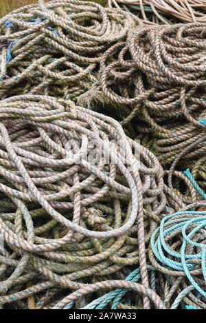 Close up of fisherman’s ropes piled on the harbour on a wet rainy day. Stock Photo