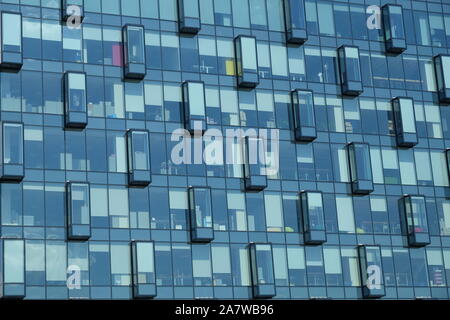 Glass wall of modern office building with many large panoramic windows in business cluster front view close-up Stock Photo