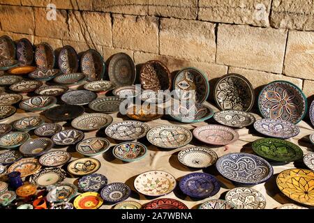 Beautiful and colorful ceramic plates for sale at a medieval market stall Stock Photo